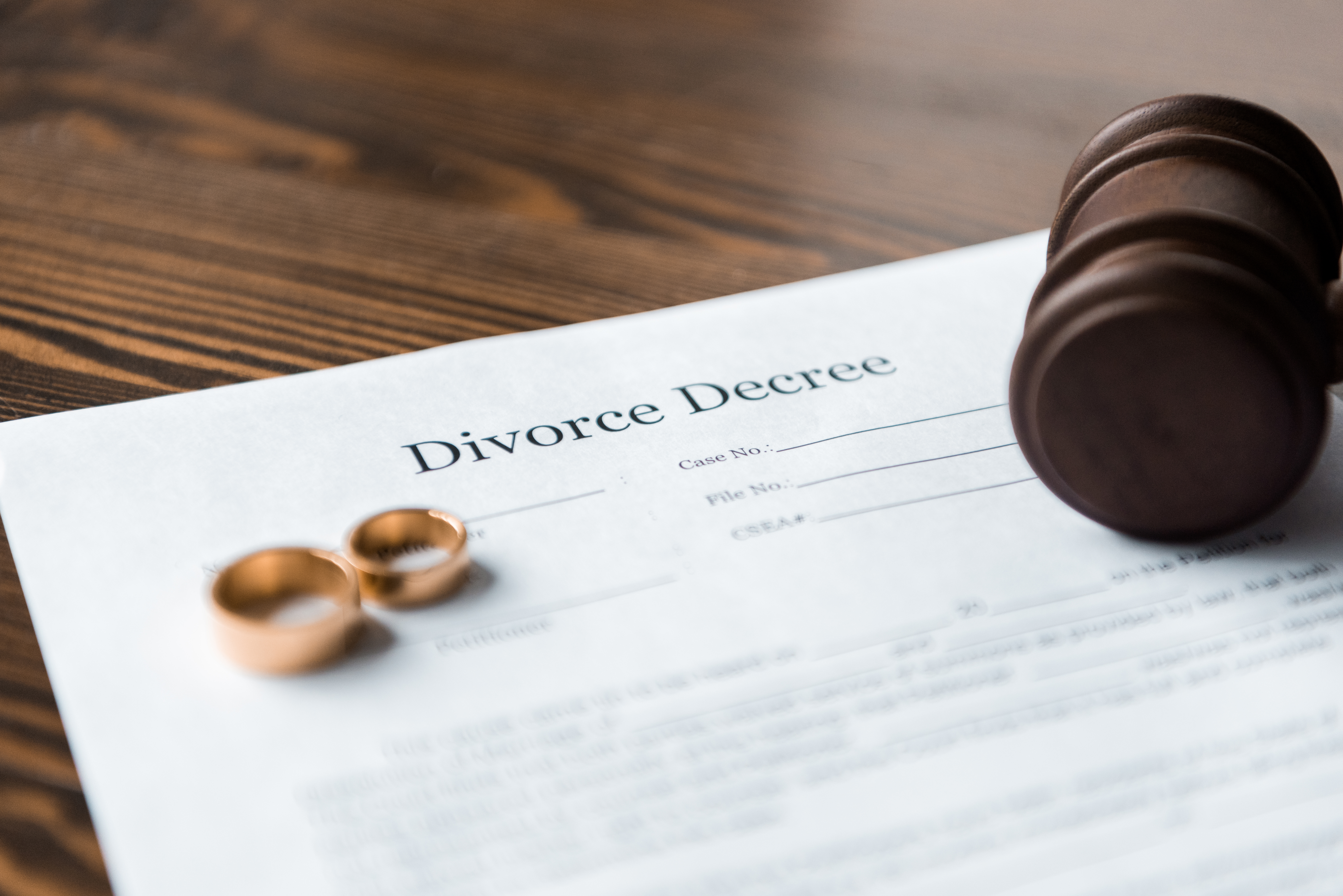 close-up view of divorce decree, wedding rings and wooden hammer